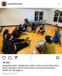 Screenshot of Instagram post by "nayouthcenter." Photo of young people sitting on the floor in a circle with ɫɫ facilitator. Caption: "tonight the senior youth council had some guest speakers talk to them about mental and physical health for teenagers!" Dated February 8, 2023.